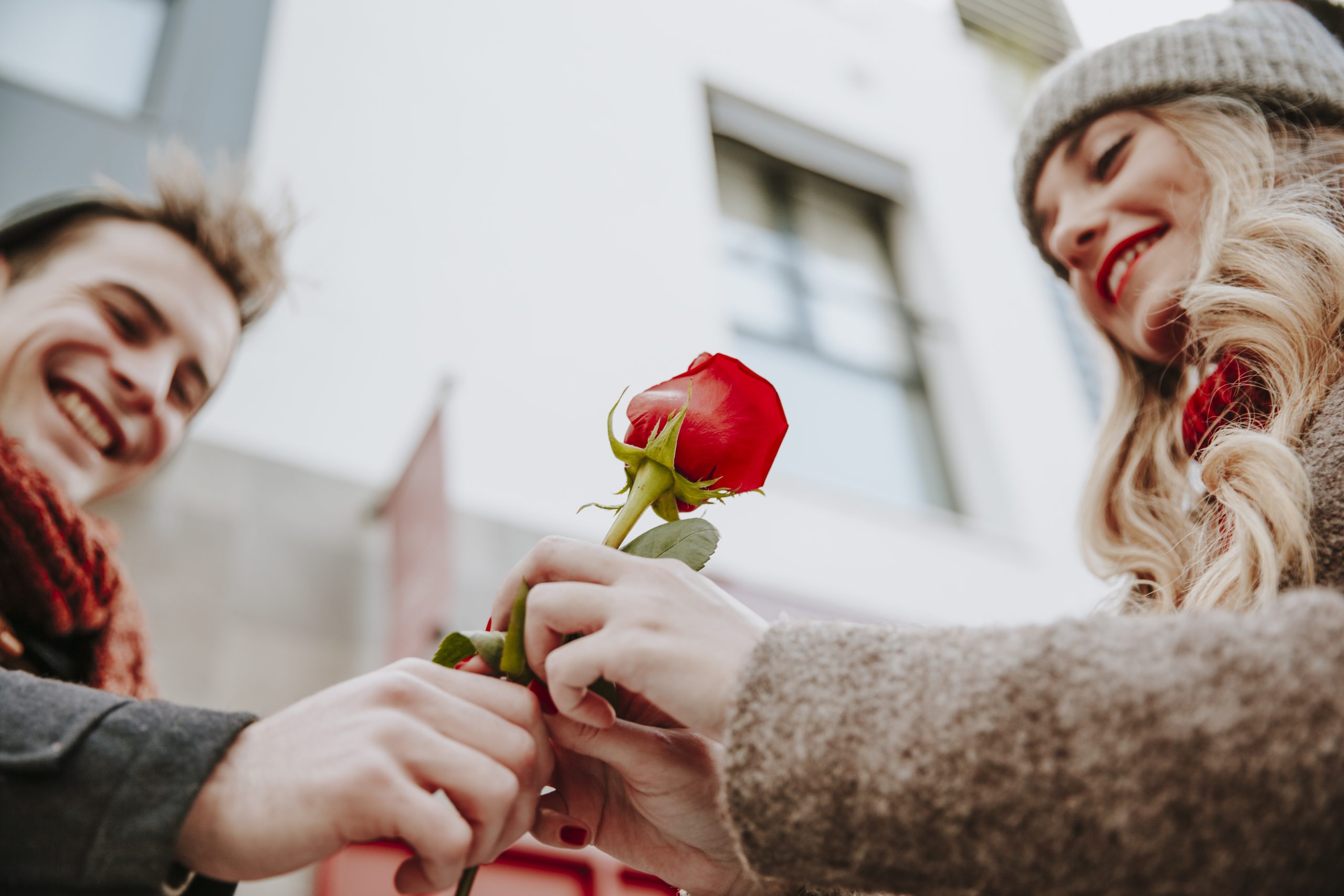 happy woman taking rose from man scaled